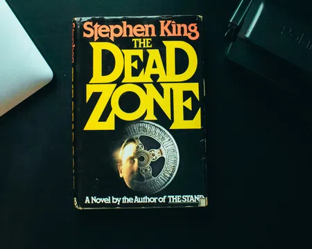 Stephen King’s novel The Dead Zone with overlaid title text in yellow on a black book cover.
