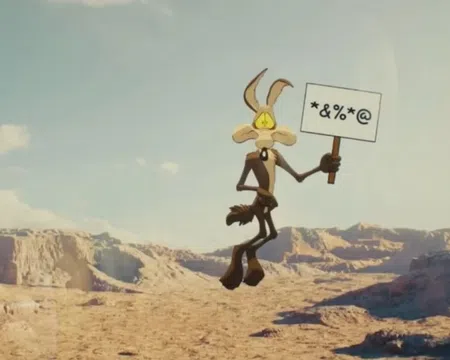 Cartoon coyote holds a sign with symbols in a desert canyon landscape under a clear sky.