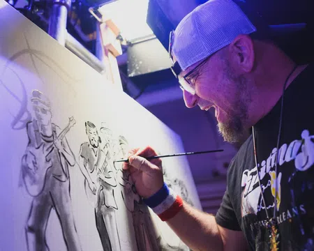 Artist in cap painting a monochrome group portrait on canvas in a studio with focused expression