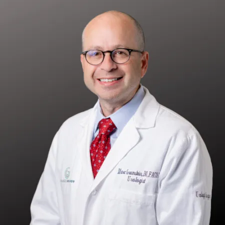 a man wearing a white coat and red tie