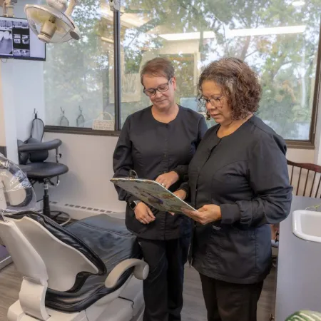 Two dental professionals reviewing patient information in a bright pediatric dental office.