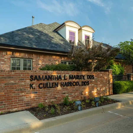 Brick dental office building with signage for Samantha L Marley DDS and K Cullen Harrod DDS under blue sky.