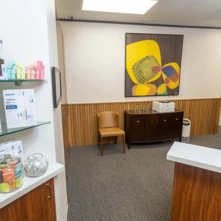 Modern dental office reception area with Philips product display, abstract wall art, and wooden furniture.