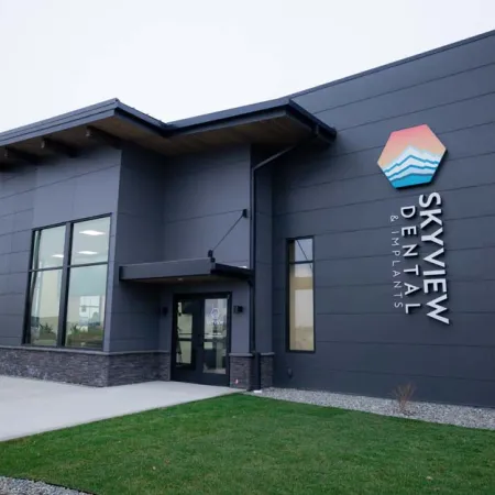 Modern Skyview Dental & Implants building with dark exterior and colorful logo on corner wall