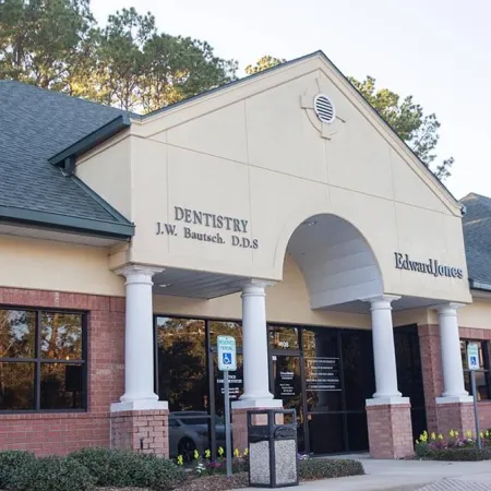 Exterior view of a brick office building housing a dentistry clinic and Edward Jones financial services with columns and handicap parking.