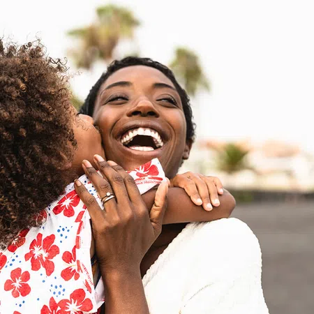Joyful mother and child sharing a loving moment on a sunny beach, captured in a warm and playful embrace.