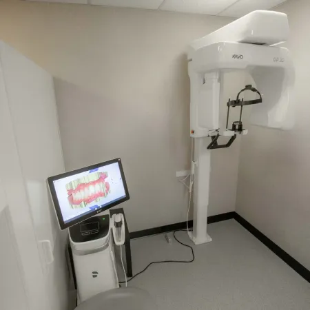 Dental imaging room with KaVo OP 3D machine and digital screen showing 3D teeth scan in sterile environment.