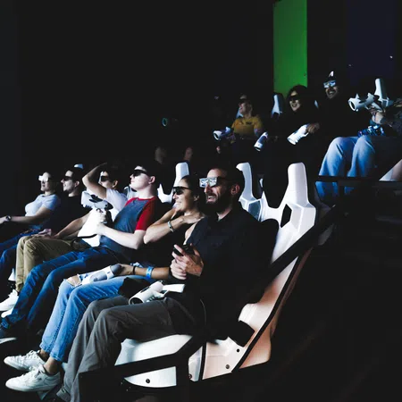 People wearing 3D glasses seated in a dark theater enjoying an immersive movie experience.