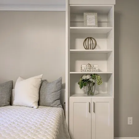 a bed with a shelf and a white cabinet