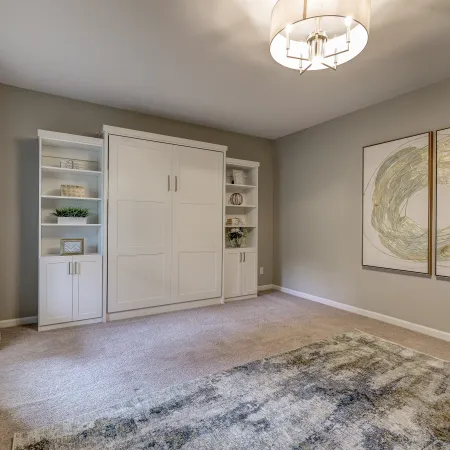 a room with a white door and a white cabinet with a picture on it