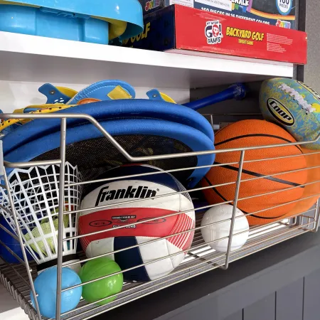 a shelf with a basket of balls and a basketball