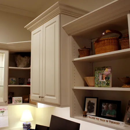 a white cabinet with shelves and baskets