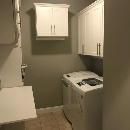 a laundry room with white cabinets