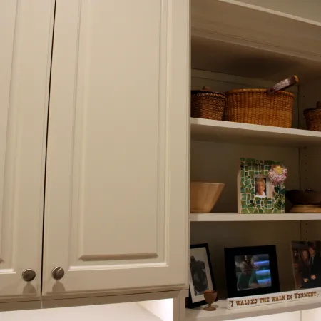 a white cabinet with shelves and baskets