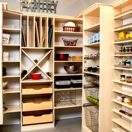 Organized pantry with wooden shelves, drawers, wire baskets, and labeled storage containers under bright lighting.