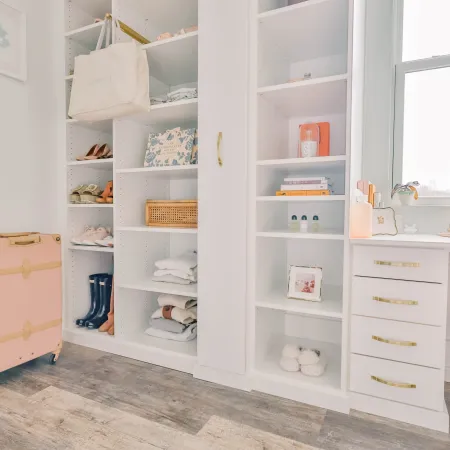 a white shelving unit with a white cabinet and a white shelf