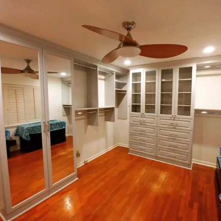 a room with a wood floor and a white door with a fan