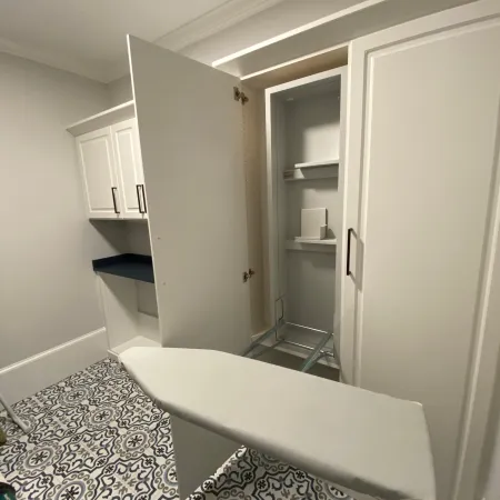 a room with a white door and a white shelf with a white cabinet