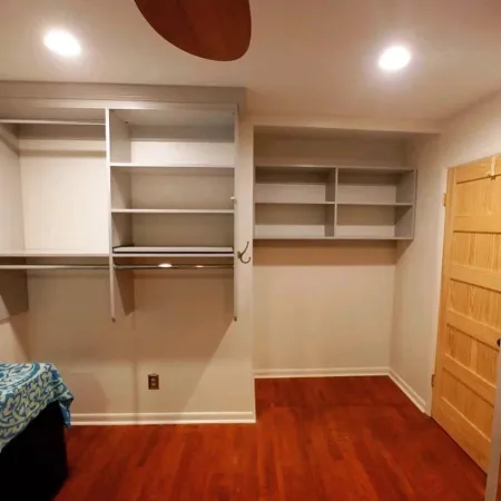 a room with a shelf and a bed