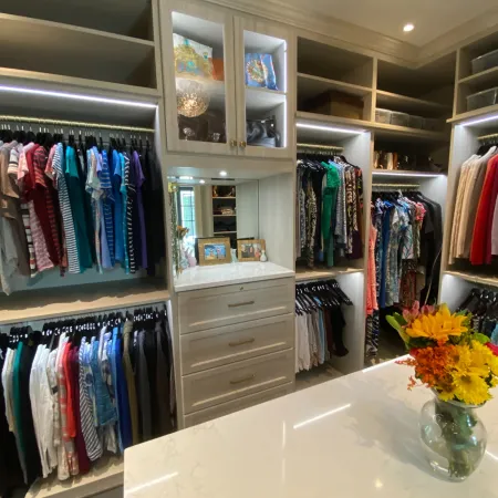 a room with a counter and shelves with clothes on it