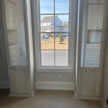 a room with a window and white cabinets