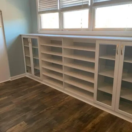 a white shelving unit in a room with a window