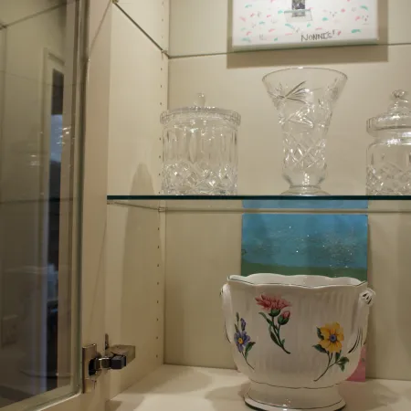 a vase and glass on a shelf