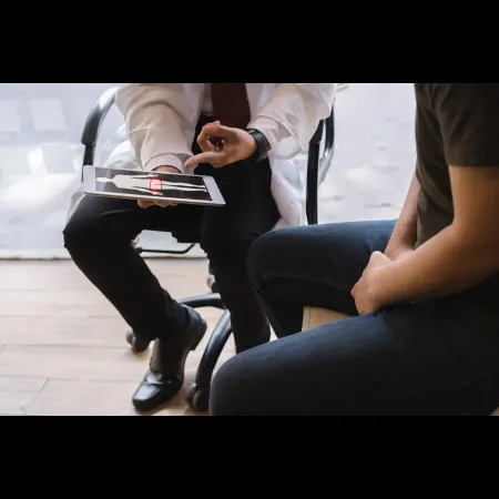 Doctor reviewing prostate health test results with a male patient on a digital tablet during a consultation about BPH and treatment options.