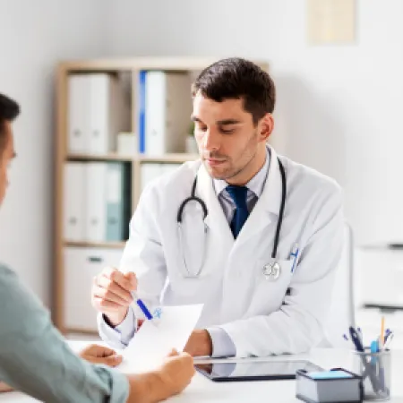 Doctor discussing prostate cancer treatment options including robotic prostatectomy and radiation therapy with a patient.