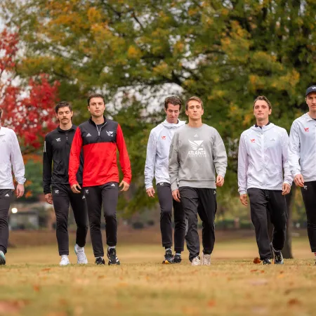 a group of men walking on a path in a park