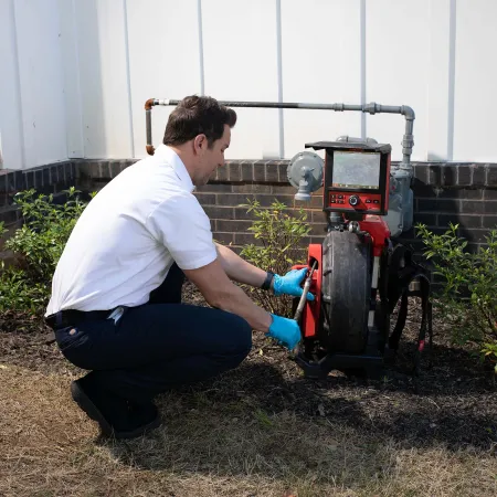 a man squatting down next to a machine