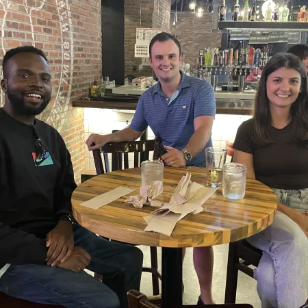 a group of people sitting at a table posing for the camera