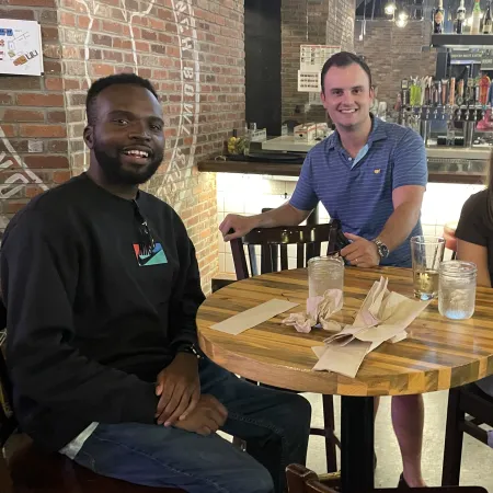 a group of people sitting at a table posing for the camera