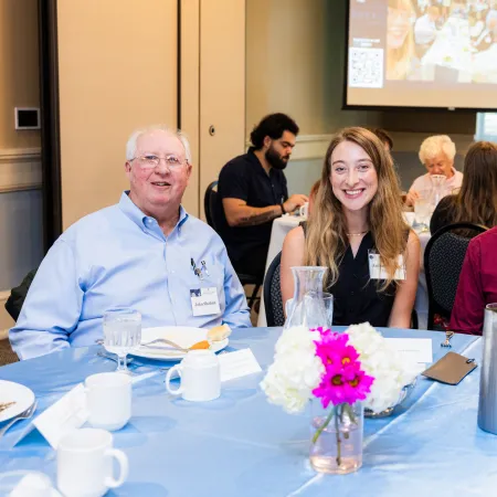 Haley Lanzoni et al. sitting at a table with food