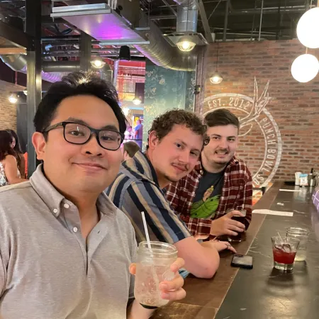 a couple of men drinking from a bottle