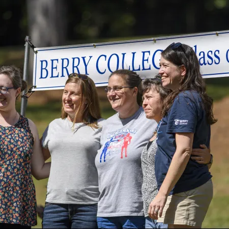 a group of people posing for a photo in front of a sign