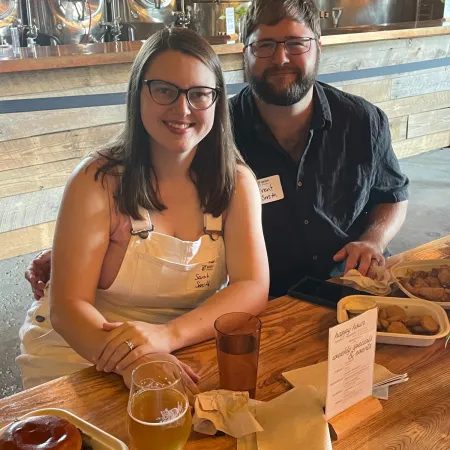 a man and woman sitting at a table with drinks