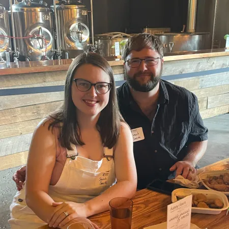 a man and woman sitting at a table with drinks