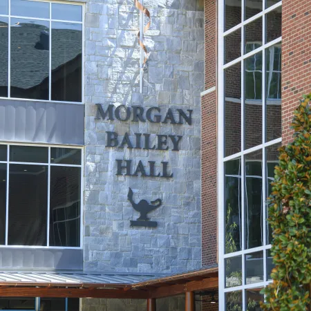 Morgan Bailey Hall building with stone and brick exterior and large reflective windows outdoors