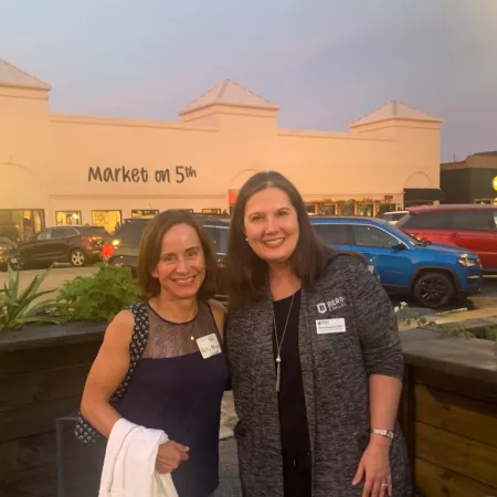 a couple of women posing for a picture in front of a building