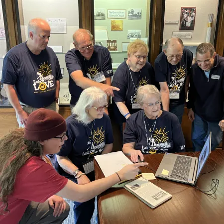 a group of people looking at a laptop