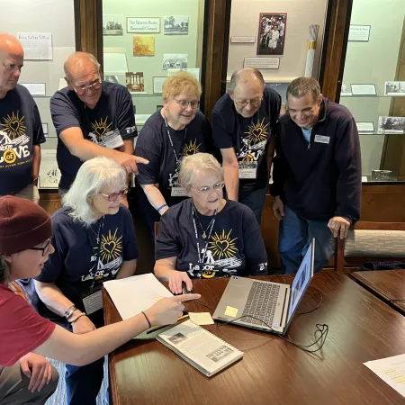 a group of people looking at a laptop