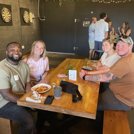 a group of people sitting at a table with food