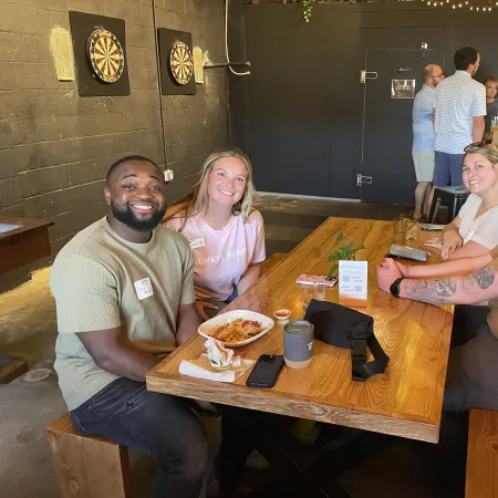 a group of people sitting at a table with food