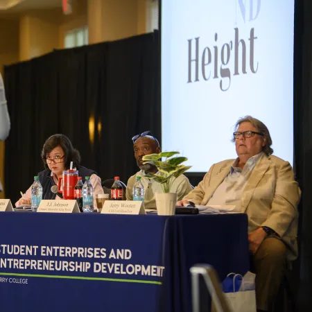 Panelists at a Berry College entrepreneurship event listen to a speaker in a conference room setting