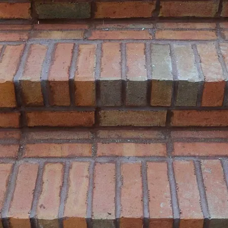 a brick walkway with a fence