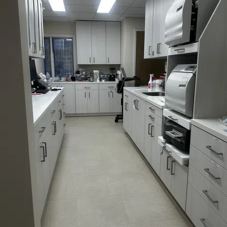 Modern clean laboratory or dental sterilization room with white cabinets, sterilizing machines, and bright overhead lighting