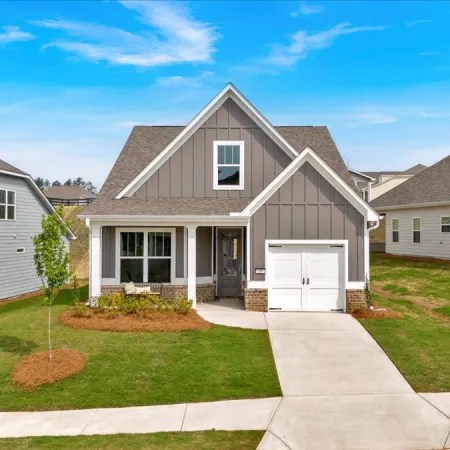 Modern single-family home with gray siding, white trim, and a one-car garage on a sunny day.