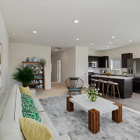 Modern open-concept living room and kitchen with neutral colors, green accents, and stylish furniture arrangement