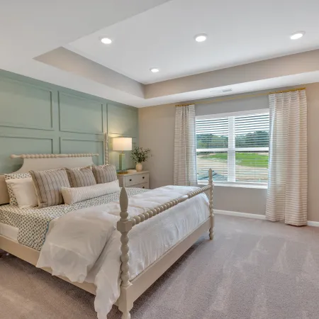 Modern bedroom with light colors, stylish furniture, and ample natural light from the window.